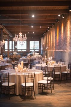 a banquet room set up with round tables and white flowers on the centerpieces