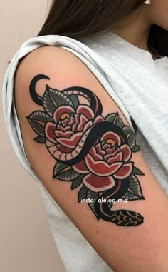 a woman with a snake and roses tattoo on her arm, holding onto the arm