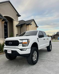 a white truck parked in front of a house