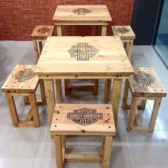 a group of wooden tables and stools sitting on top of a white tile floor