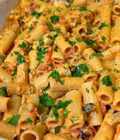 a bowl filled with pasta covered in sauce and parsley