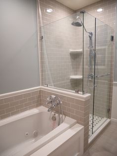 a bath tub sitting next to a walk in shower