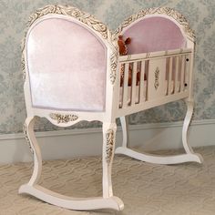 a white baby crib with pink bedding on it