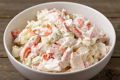 a white bowl filled with chicken salad on top of a table