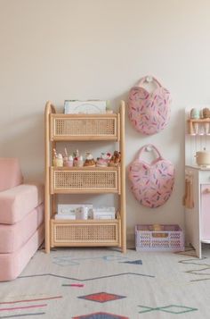 a living room filled with furniture and pink accents on the walls, including a shelf