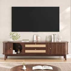 a living room with a large tv mounted on the wall and a coffee table in front of it