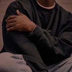 a man sitting on the ground with his arms crossed