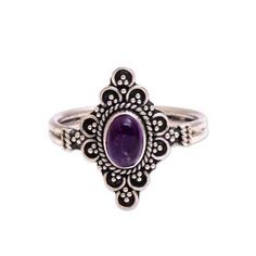 a silver ring with an oval purple stone in the center