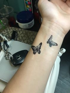 a woman's arm with a small butterfly tattoo on the left side of her wrist