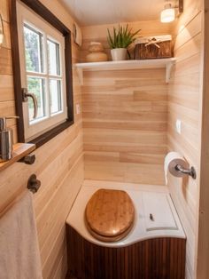 a bathroom with wooden walls and flooring in the corner, along with a window