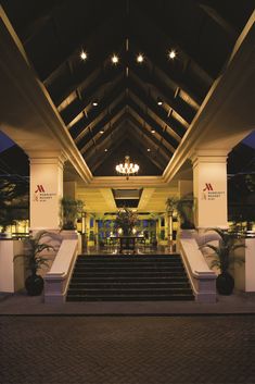 the entrance to a hotel with stairs leading up to it and chandeliers hanging from the ceiling