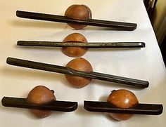 five wooden spoons and some metal tongs on a table