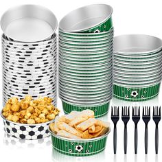 a table topped with lots of plates and cups filled with food next to black and white containers