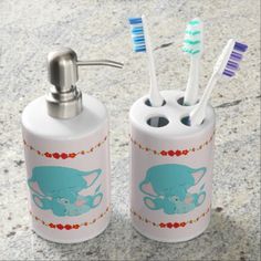 two toothbrush holders with red lobsters on them and one blue toothbrush holder