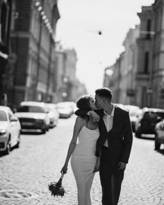 a man and woman kissing on the street