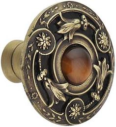 an antique style door knob with a brown stone in the center and flowers on it