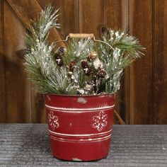 a potted plant with pine cones and snow flakes in it sitting on a table