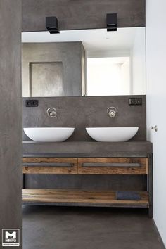 two white bowls sit on top of a wooden counter in front of a large mirror