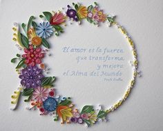 a white card with colorful flowers in the middle and spanish words on it's side