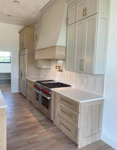 a kitchen with an oven, stove and cabinets inside of it on a hard wood floor