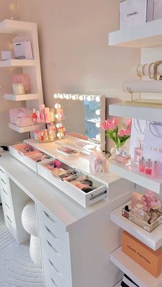 a white desk topped with lots of makeup and cosmetics bottles on top of it's drawers