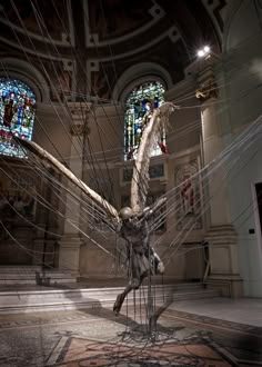 a sculpture in the middle of a room with stained glass windows