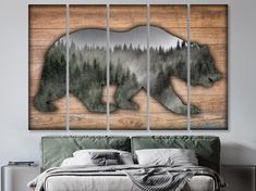 a bear is walking in the woods on a wood paneled wall above a bed