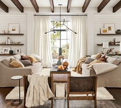 a living room with two couches and a table in front of a large window