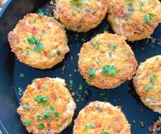 cooked crab cakes in a skillet with parsley on the top, ready to be eaten