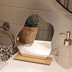 a bathroom sink with a mirror and soap dispenser on top of it