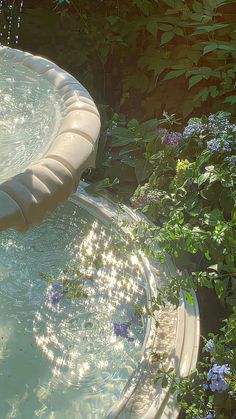 an inflatable swimming pool surrounded by flowers and greenery with water spouting from it