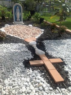 a garden with rocks and stones in the shape of a cross on top of it