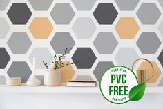 a white shelf topped with vases next to a wall covered in hexagonal tiles