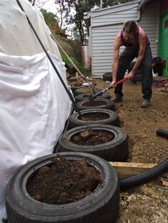 a man is digging dirt in front of some tires