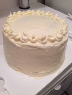 a white frosted cake sitting on top of a counter