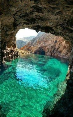 the water is crystal blue and green in this cave entrance, which looks like it could be underwater