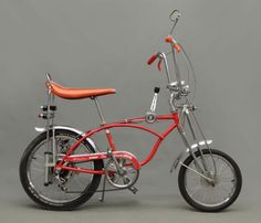 a red bicycle with an orange seat on a gray background