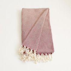 a red and white towel with fringes on it