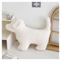 a white dog stuffed animal next to a book shelf