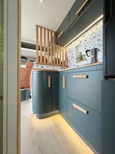 a kitchen with blue cabinets and wooden stairs