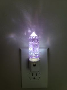 a light that is on top of a wall with a purple light shining through it