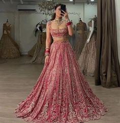 a woman in a red and gold wedding dress taking a selfie