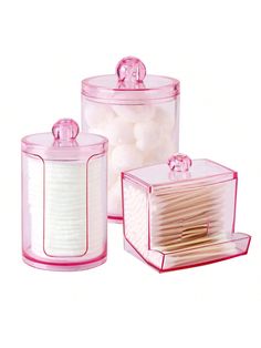 three plastic containers filled with white cotton swabs and some pink stuff in them