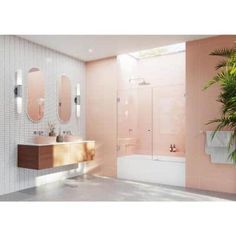 a bathroom with pink walls and white tiled flooring, two round mirrors on the wall