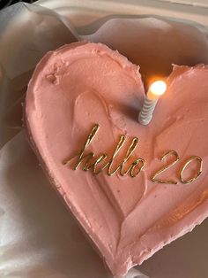 a pink heart shaped cake with a candle in the middle that says hello 22 on it