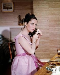 a woman in a pink dress sitting at a table