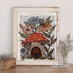 an old book page with a mushroom house and flowers on it next to a potted plant