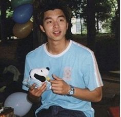 a young man is holding a stuffed animal