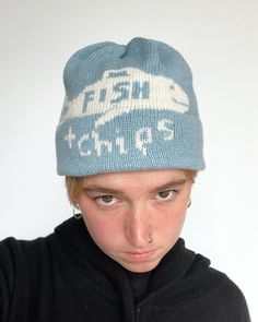 a young man wearing a blue hat with white lettering on it