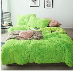 a bright green bed in a bedroom with pictures on the wall above it and an animal print rug